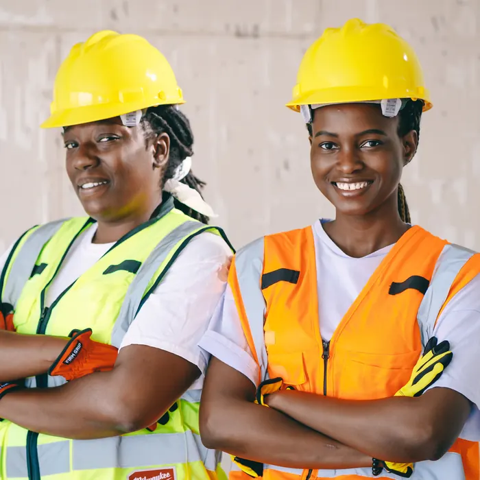 Two female technicians in hard hats and high-visibility vests